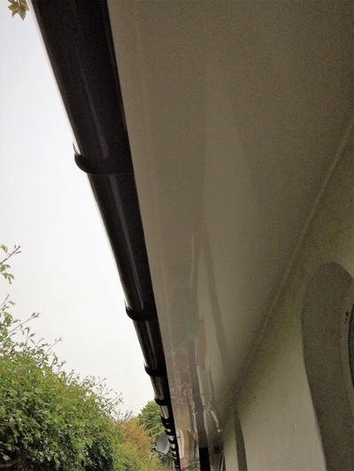 White fascia and soffit with black deep flow half round guttering UPVC